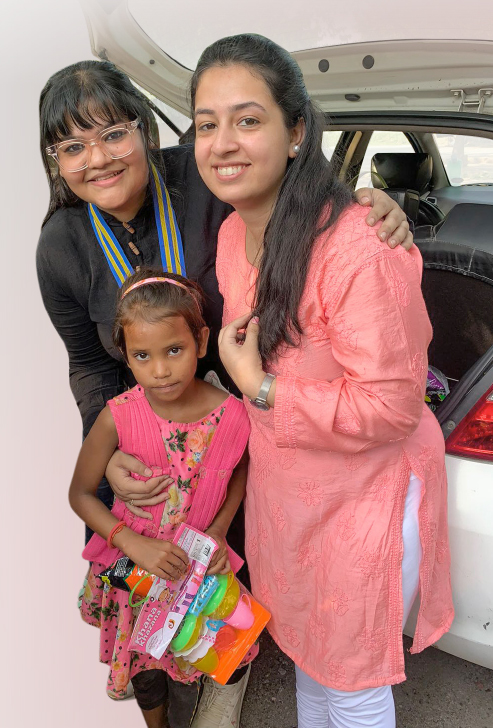 Mahi Bhan, charter president, E-Club of Inspiring India and club treasurer Medha Tankha (R) from Dehradun gift toys to a little girl in Lucknow.