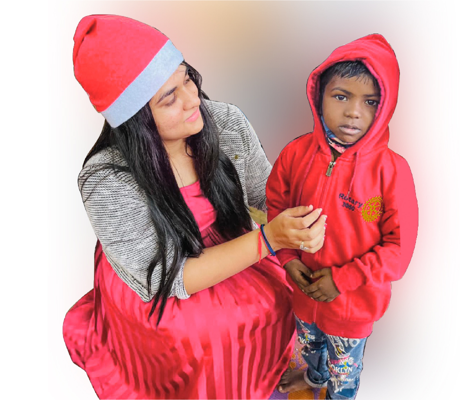RAC Vapi president Pooja Shah with a little boy after gifting him a sweater.
