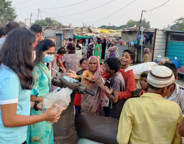 Rotaractors distribute biscuits at a slum area.