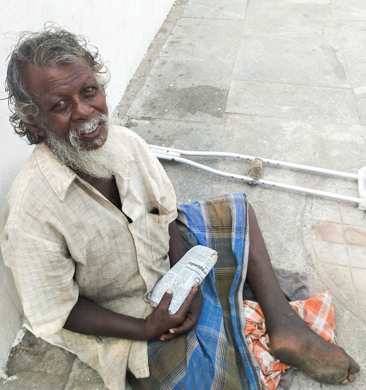 A physically-challenged man with a food packet given to him by the club