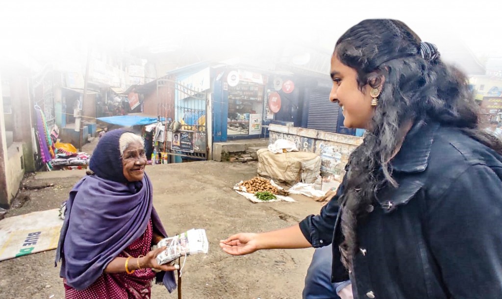 A Rotaractor giving a food packet to an elderly woman.