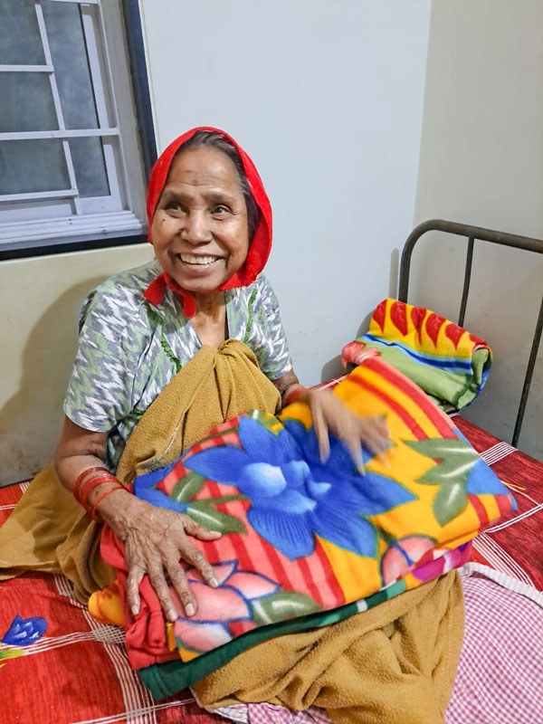 A beneficiary with a woollen blanket.