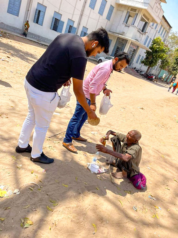 A food packet being given to a homeless person under Project Udgam.