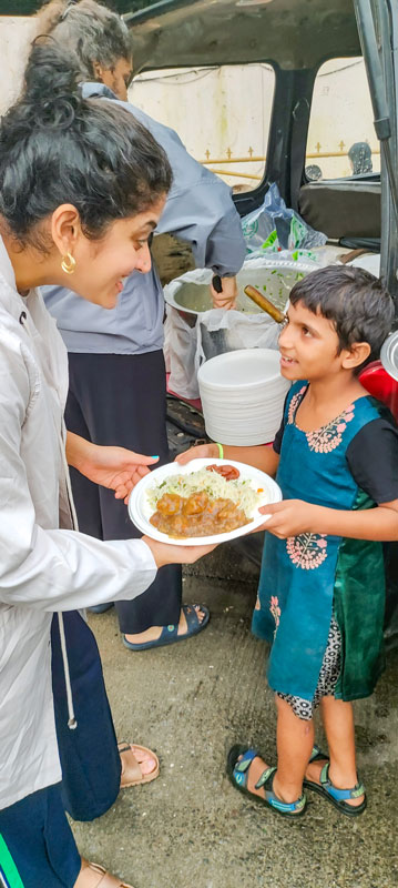 A Rotaractor serves food to a child.