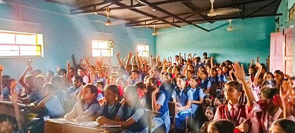 Schoolchildren interacting with Rotaractors during a lecture on drug abuse.