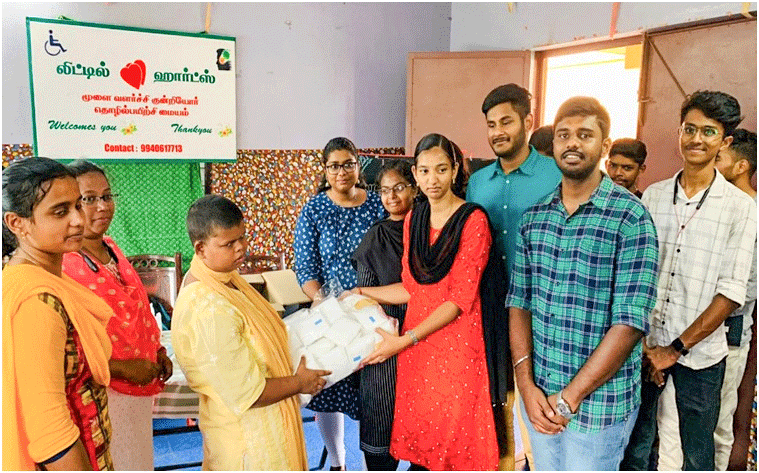 A Rotaractor donates sanitary pads to an inmate of Little Hearts in the ­presence of Club’s IPP G Karthik (2nd from R) and other members.